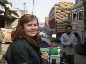 Picture of Cathy at the Nepal border surrounded by Indian Wagons. She has a very big grin on her face - we made it!