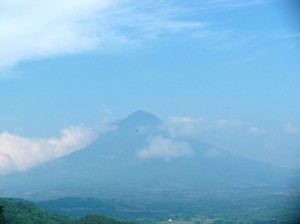 Picture of one of the many volcanoes which inhabit this part of the world. It is in the distance and the whole scene is blue due to the brightness of the sun.