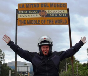 Picture of Cathy with her arms out in a victory wave underneath the sign indicating we have reached the centre of the world.